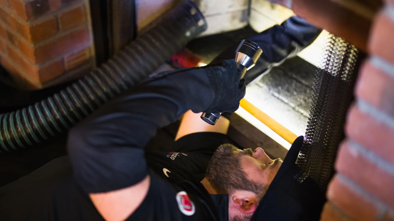 Technician inspecting the inside of a chimney with a flashlight