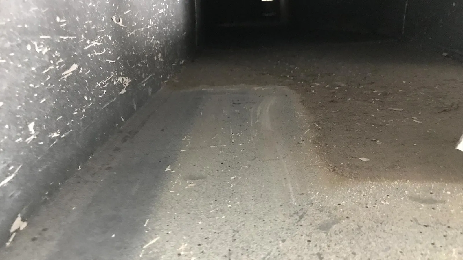 Interior view of a dirty air duct in a Phoenix home showing accumulated dust and debris
