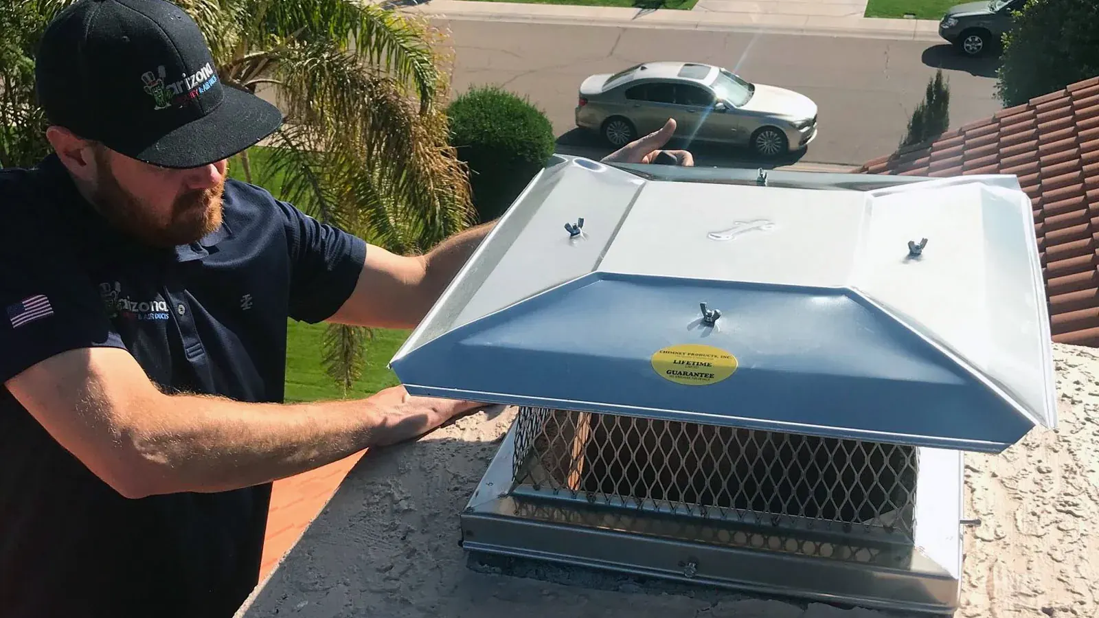 Technician installing a stainless steel chimney cap