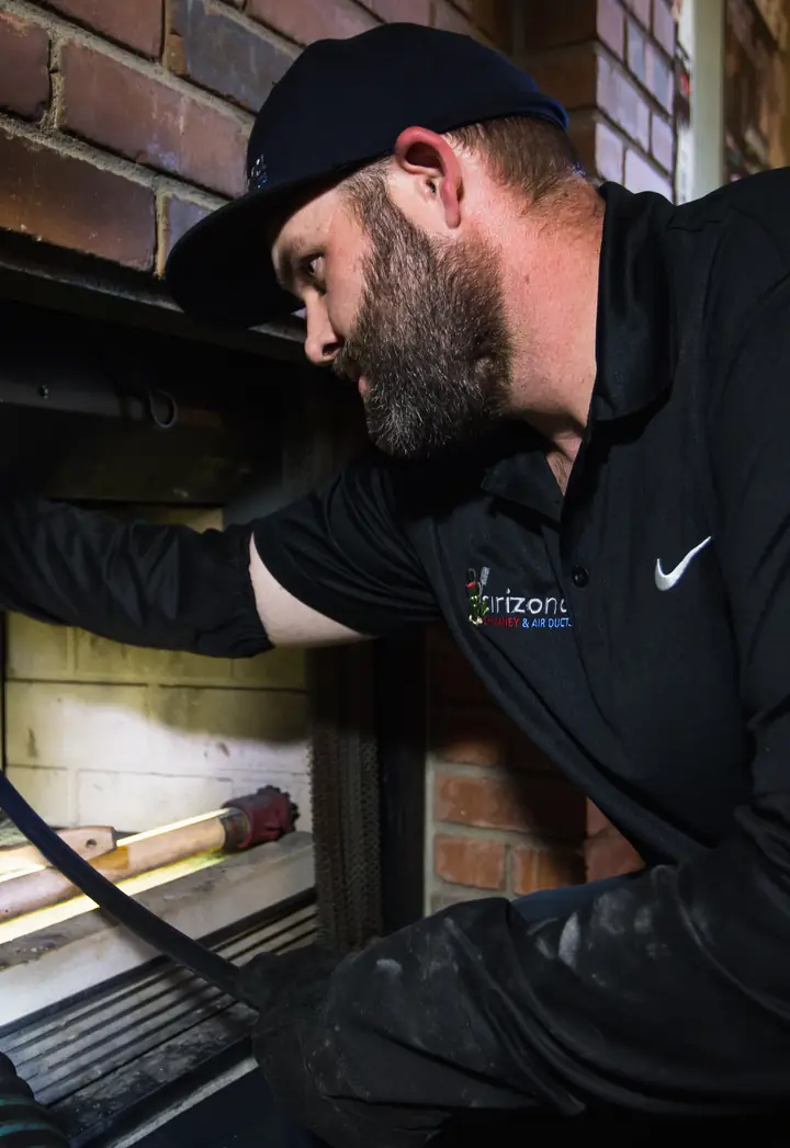 Technician sweeping a brick fireplace
