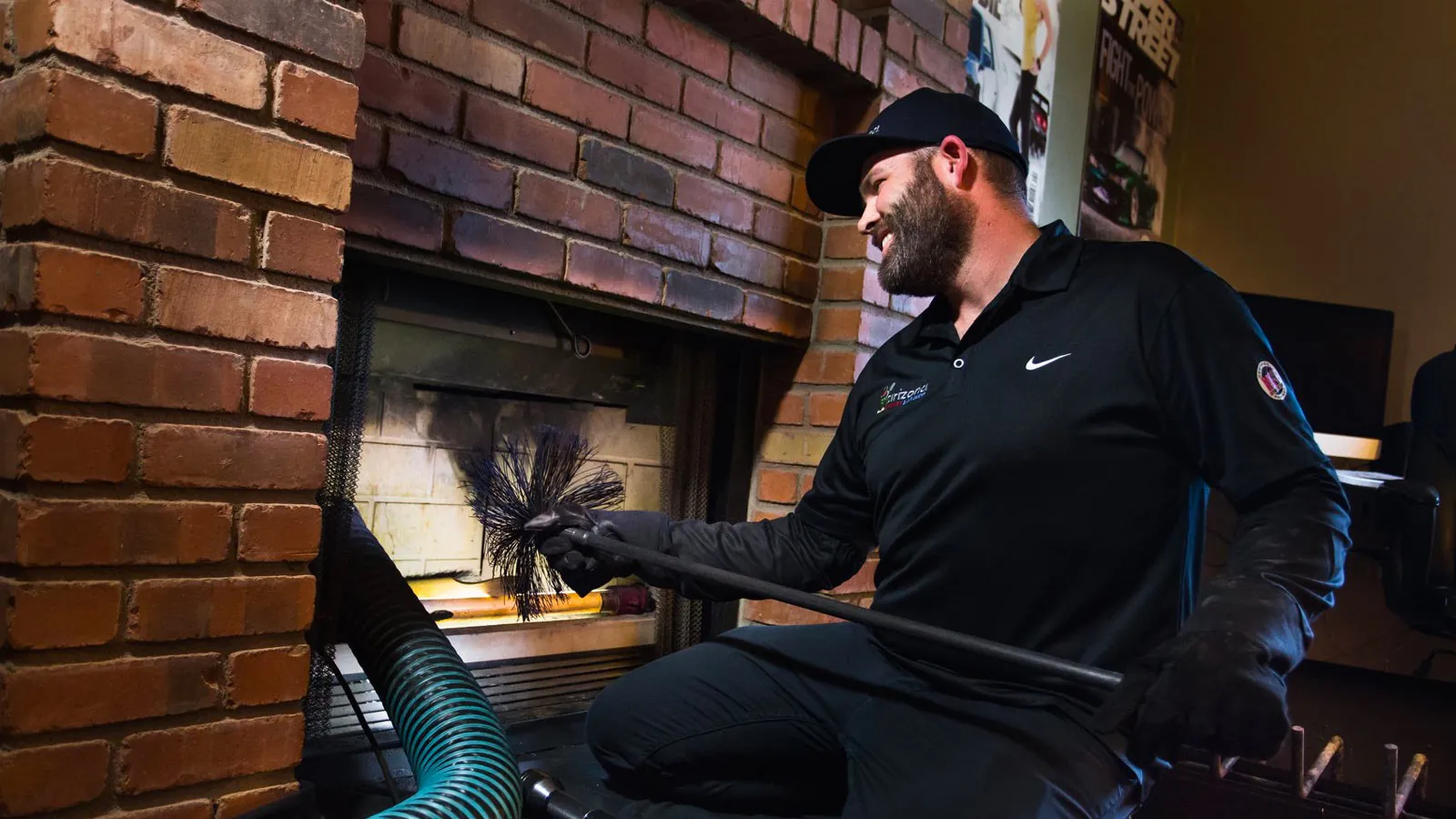 Technician sweeping a brick fireplace with a rotary brush