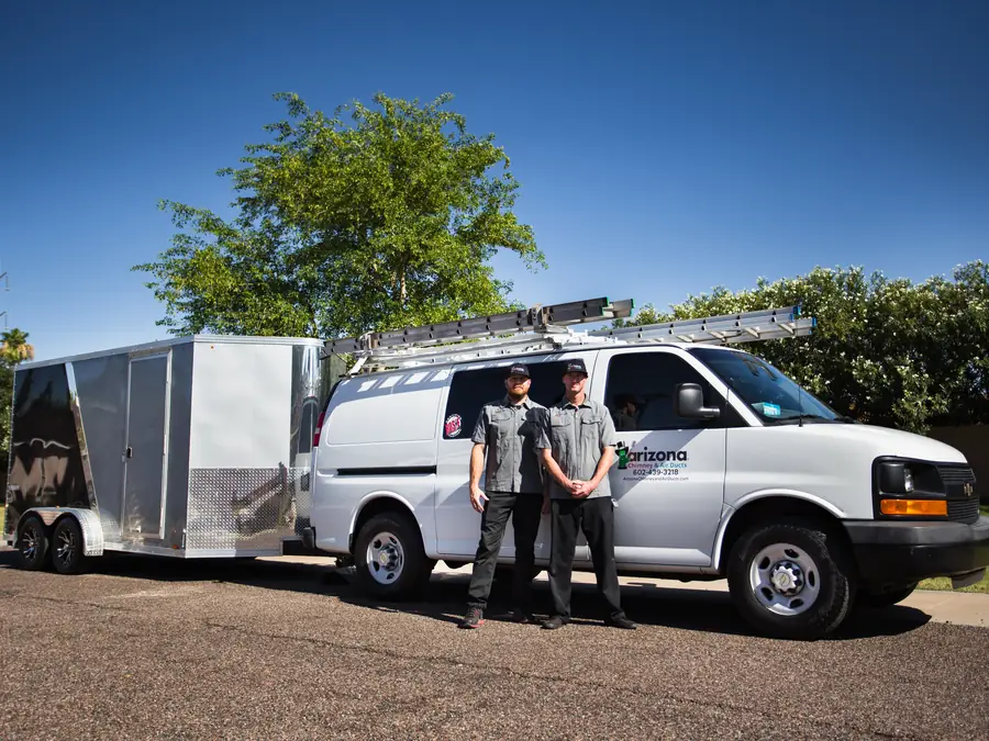 Two technicians with a company van and equipment trailer