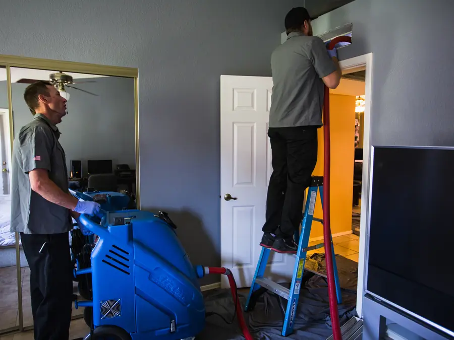 Technicians performing a whole-house air duct cleaning